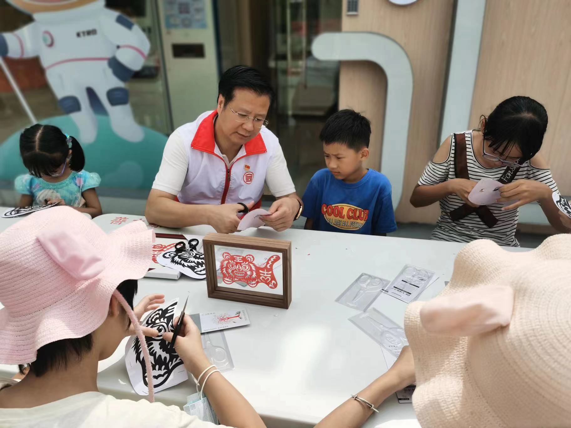 金赋智慧便民志愿V站，开展志愿服务公益活动，.任总与参与的小朋友一起剪纸国粹、文化传承.jpeg